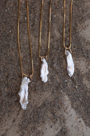 Three Elara necklaces side by side to show the variation in natural pearl pendants used.