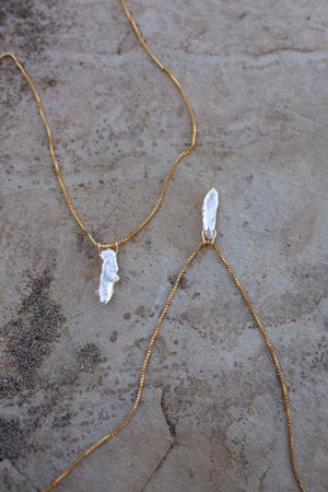 Two gold necklaces with long flat white pearl pendant