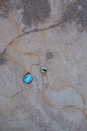 Alternate view of three Nereida abalone and gold necklaces