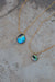 Close up view of venetian gold chain with abalone pendants in large and small sizes. Abalone pendants are iridescent blue and green rainbow swirls.