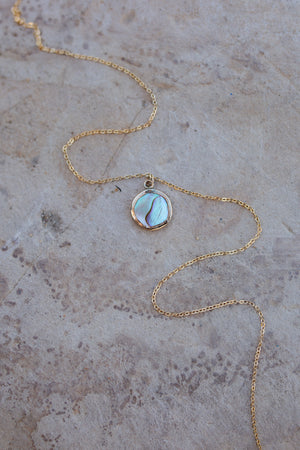 Abalone set in a round gold bezel with a dainty cable chain