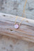 Mother of pearl necklace with gold bail and chain resting on a piece of driftwood